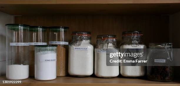 jars of flour and sugar on a wooden shelf - speisekammer stock-fotos und bilder