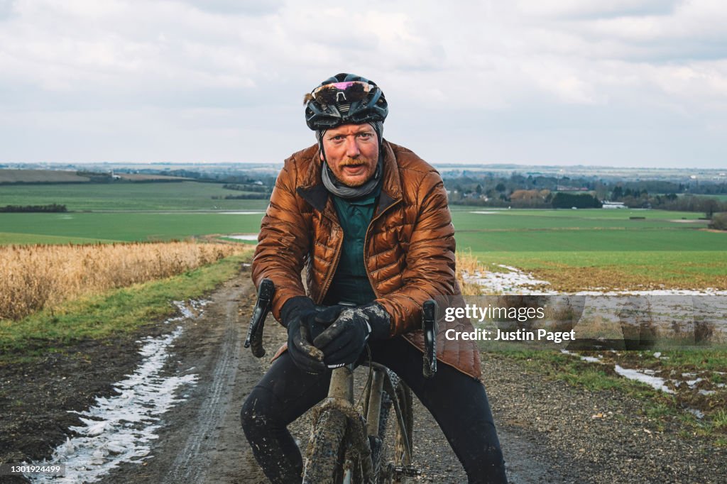 Portrait of an adventure cyclist on dirt track