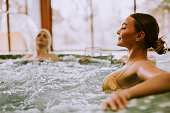 Young women relaxing in the whirlpool bathtub at the poolside