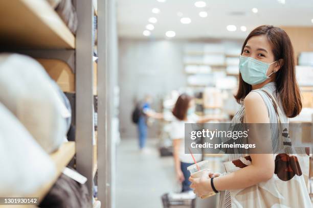 womеn wearing protective mask and shopping after reopening stores after covid-19 at retail store. shopping sale after reopening - store opening covid stock pictures, royalty-free photos & images