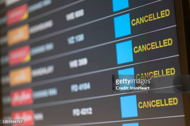 departure flight board with cancelation at the airport. - cancelación fotografías e imágenes de stock