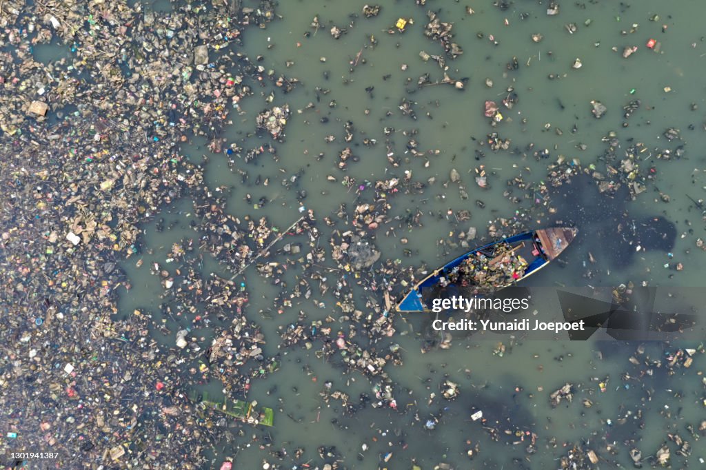 Plastic Pollution in the Ocean; Man Cleaning Plastic Pollution in the Sea