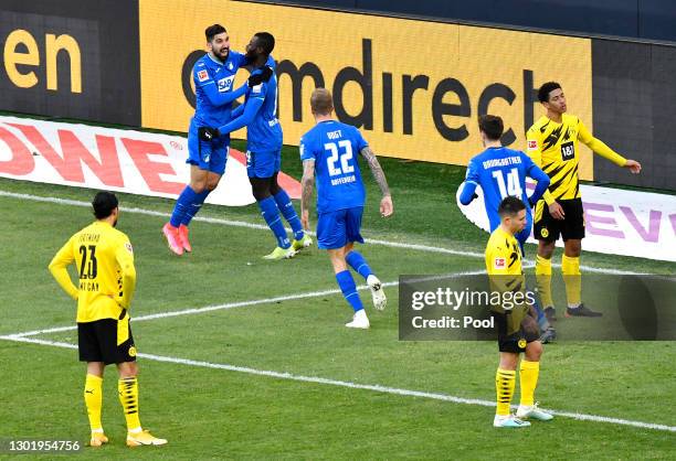 Ihlas Bebou of TSG 1899 Hoffenheim celebrates with teammate Munas Dabbur after scoring his team's second goal, as Emre Can, Raphael Guerreiro, and...