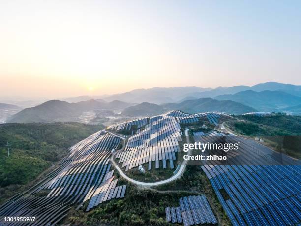 aerial view of a solar power plant in harmony with plants on the mountain - symbiotic relationship stock-fotos und bilder