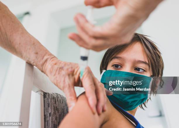 little boy being vaccinate at senior doctor's office - kid studio shot stock pictures, royalty-free photos & images