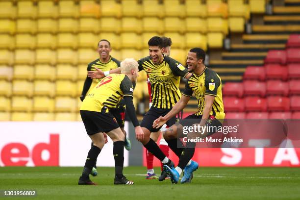 Will Hughes of Watford celebrates with teammates Adam Masina and William Troost-Ekong after scoring his team's third goal during the Sky Bet...