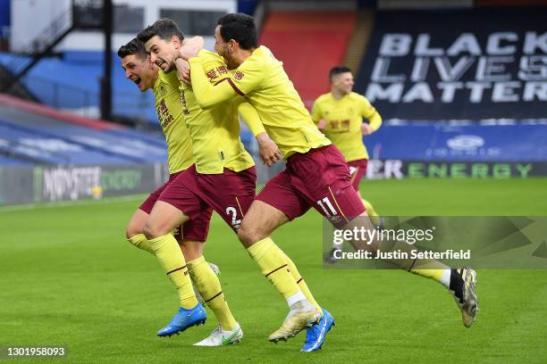 Matthew Lowton of Burnley celebrates with teammates Ashley Westwood and Dwight McNeil after scoring his team's third goal during the Premier League...