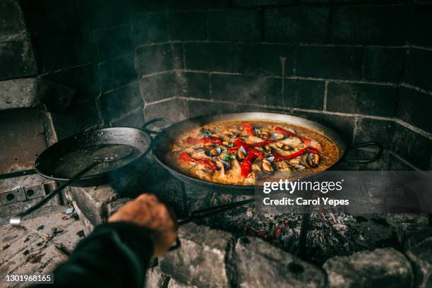 cooking spanish paella outdoors.pov - spanish food stock pictures, royalty-free photos & images