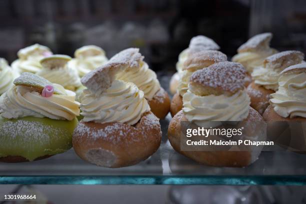 semla (plural semlor) are traditional swedish cream buns, with almond paste, eaten on, or before, shrove tuesday in sweden / scandinavia. - pancake day - fotografias e filmes do acervo