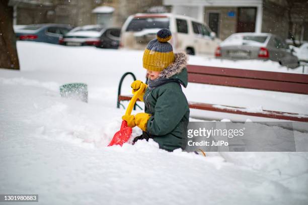 het spelen van het kind in sneeuw - alleen jongens stockfoto's en -beelden