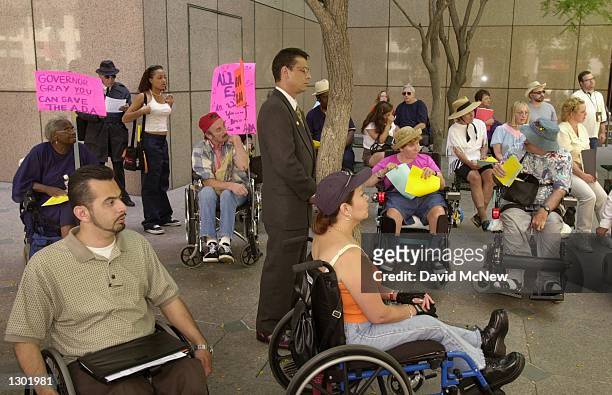 Eric Bauman, assistant to California Governor Gray Davis, stands waiting June 13, 2000 to defend the governor to demonstrators protesting the state...