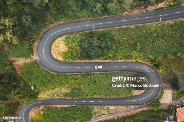 car driving on winding mountain road - s vorm stockfoto's en -beelden