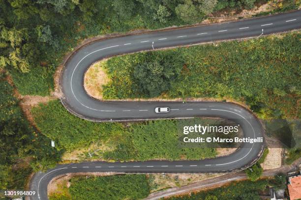 car driving on winding mountain road - s imagens e fotografias de stock