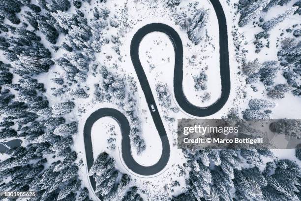 aerial view of winding road in winter forest - curve road stock pictures, royalty-free photos & images