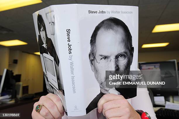 Biography of Apple co-founder Steve Jobs is pictured held by a reader in New York, October 24, 2011. The eagerly awaited biography of Apple...