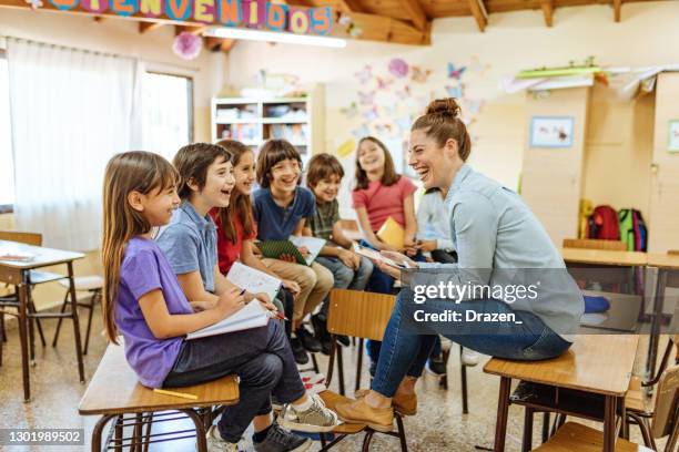 female latina teacher with hispanic kids in classroom at school - primary school classroom stock pictures, royalty-free photos & images