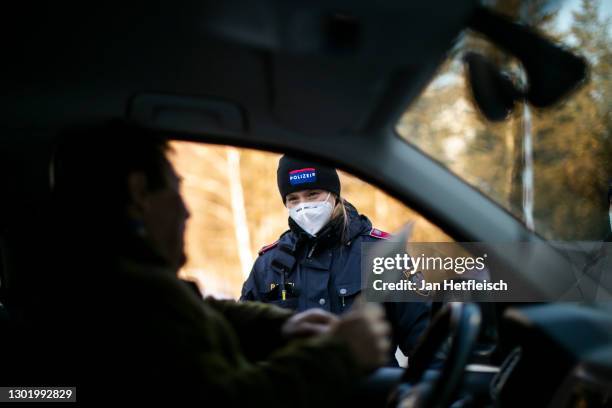 Member of Austria's border police speaks to a driver at a checkpoint on the border to Germany following new border policies in the state of Tyrol on...