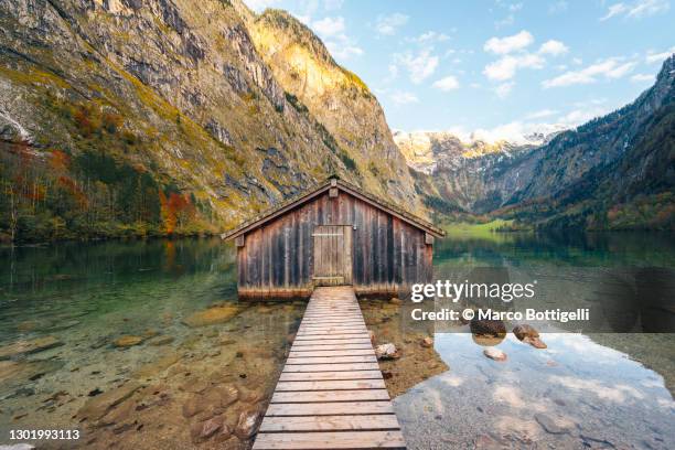lonely boathouse on mountain lake, bavaria, germany - berchtesgaden nationaal park stockfoto's en -beelden