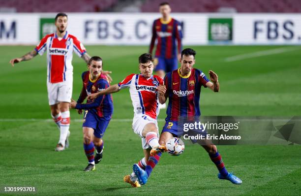 Martin Aguirregabiria of Deportivo Alaves battles for possession with Sergio Busquets of FC Barcelona during the La Liga Santander match between FC...