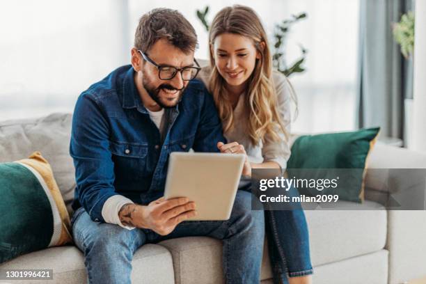 couple at home - couple with ipad in home stock pictures, royalty-free photos & images