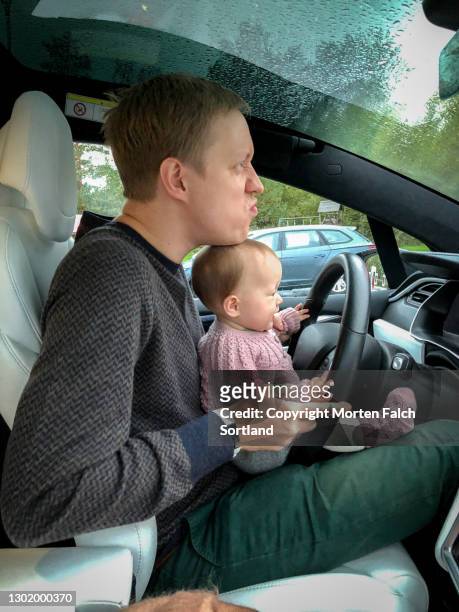 daddy and baby sitting on the driver's seat in arboga, sweden - arboga stock pictures, royalty-free photos & images
