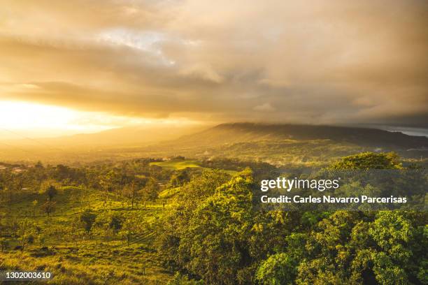volcano covered by a cloud and surrounded by a forest. arenal volcano, la fortuna, costa rica - prähistorisches zeitalter stock-fotos und bilder