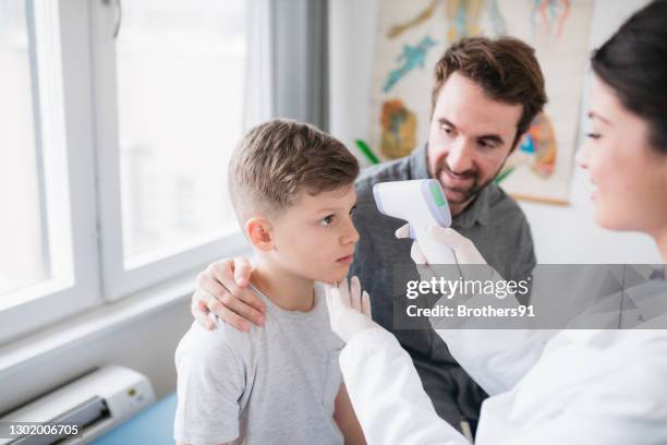 jeune garçon caucasien étant vérifié pour la température - thermomètre à affichage digital photos et images de collection
