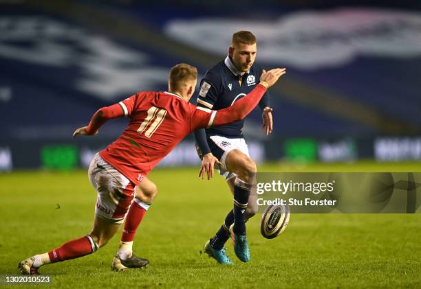 Scotland player Finn Russell kicks past Wales wing Liam Williams during the Guinness Six Nations match between Scotland and Wales at Murrayfield on...