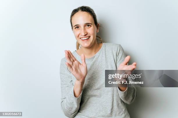 studio portrait of smiling woman applauding - lob hairstyle stock-fotos und bilder