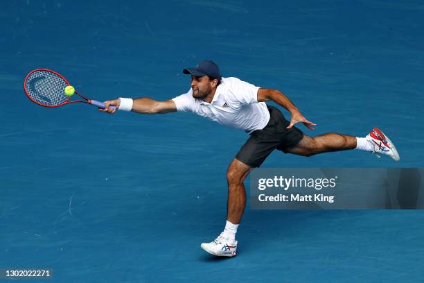 Aslan Karatsev of Russia plays a forehand in his Men's Singles fourth round match against Felix Auger-Aliassime of Canada during day seven of the...