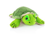 Turtle plushie doll isolated on white background with shadow reflection. Plush stuffed puppet on white backdrop. Fluffy turtle toy for children. Cute furry animal plaything for kids. Green reptile.