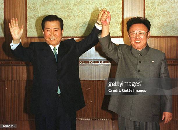 South Korean President Kim Dae-jung, left, and North Korean leader Kim Jong Il are all smiles June 14, 2000 as they raise their arms together at the...