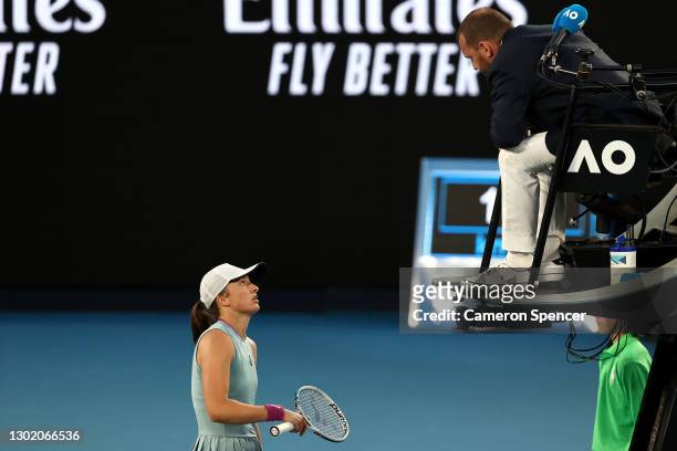 Iga Swiatek of Poland speaks with the chair umpire Damien Dumusois of France in her Women's Singles fourth round match against Simona Halep of...