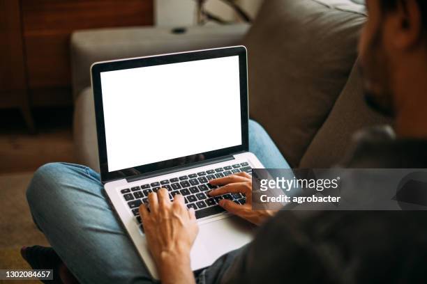mann mit laptop leeren bildschirm zu hause - blank laptop screen stock-fotos und bilder