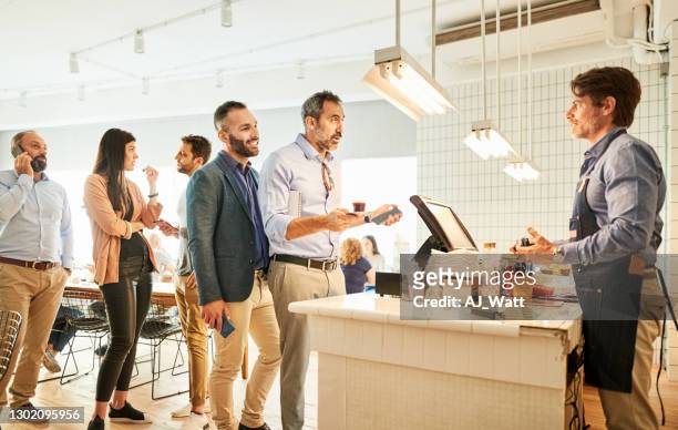barista taking order from people standing in line - line up stock pictures, royalty-free photos & images