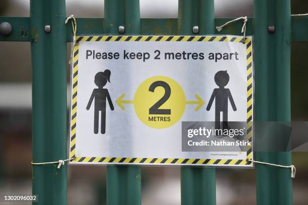 Social distancing signage is displayed onto a gate at Daven Primary School on February 14, 2021 in Congleton, England. With a surge of covid-19 cases...