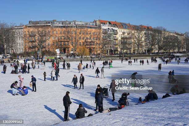 People ice skate and stroll across the frozen surface of the Landwehrkanal in Kreuzberg district during the second wave of the coronavirus pandemic...