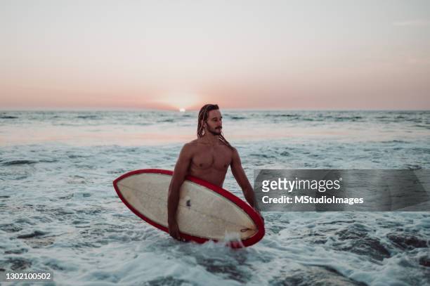 surfer saliendo del océano - océano pacífico fotografías e imágenes de stock
