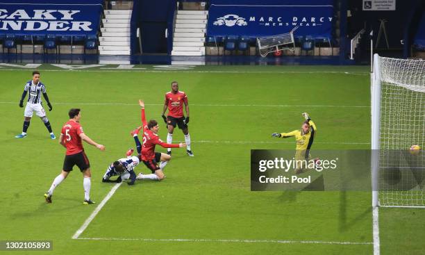 Mbaye Diagne of West Bromwich Albion scores their side's first goal under pressure from Victor Lindeloef of Manchester United during the Premier...