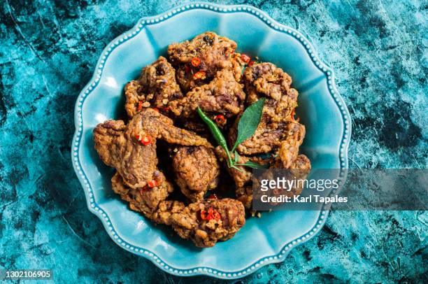 still life of spicy garlic chicken on a rustic turquoise background - fried chicken plate stock pictures, royalty-free photos & images