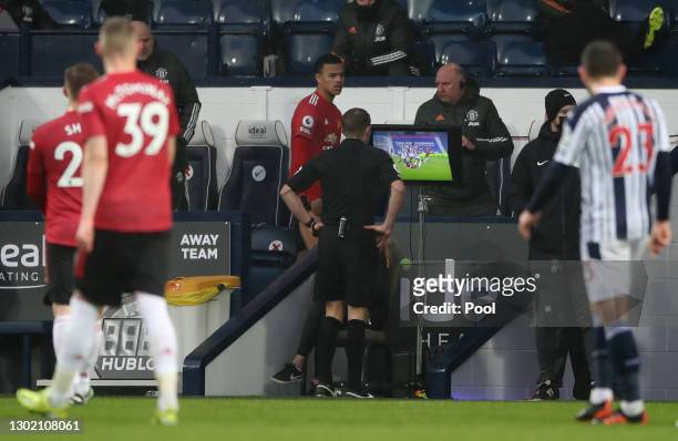 Referee, Craig Pawson checks the VAR monitor during the Premier League match between West Bromwich Albion and Manchester United at The Hawthorns on...