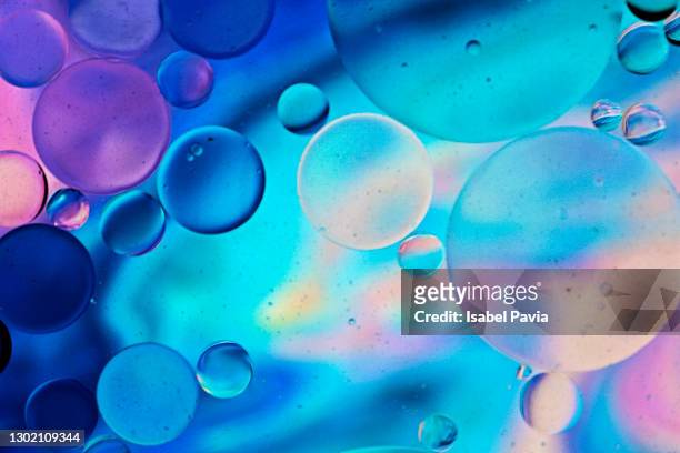 colorful image of oil drops floating on water - chemistry macro stock-fotos und bilder