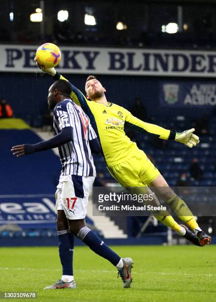 David de Gea of Manchester United makes a save from the head of Mbaye Diagne of West Bromwich Albion during the Premier League match between West...