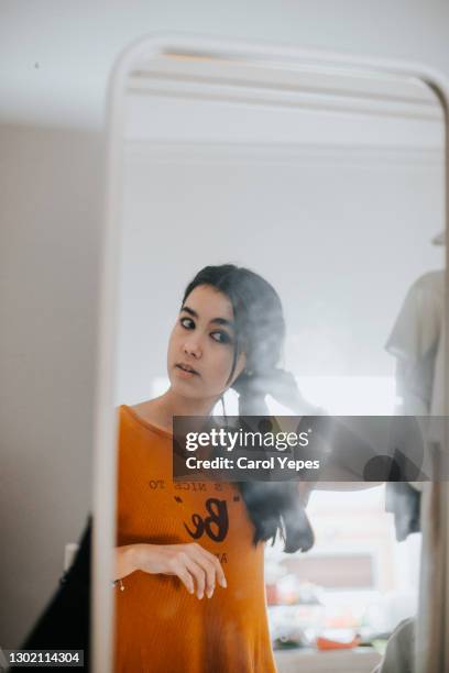 latina  young woman looking the reflection in the mirror at home - girl in mirror stock pictures, royalty-free photos & images