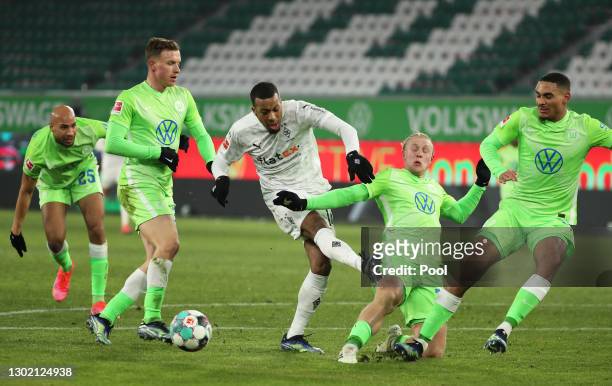 Alassane Plea of Borussia Moenchengladbach is challenged by Xaver Schlager of VfL Wolfsburg during the Bundesliga match between VfL Wolfsburg and...