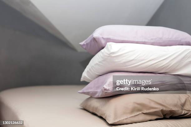 pillows piled on a bed - pillow foto e immagini stock