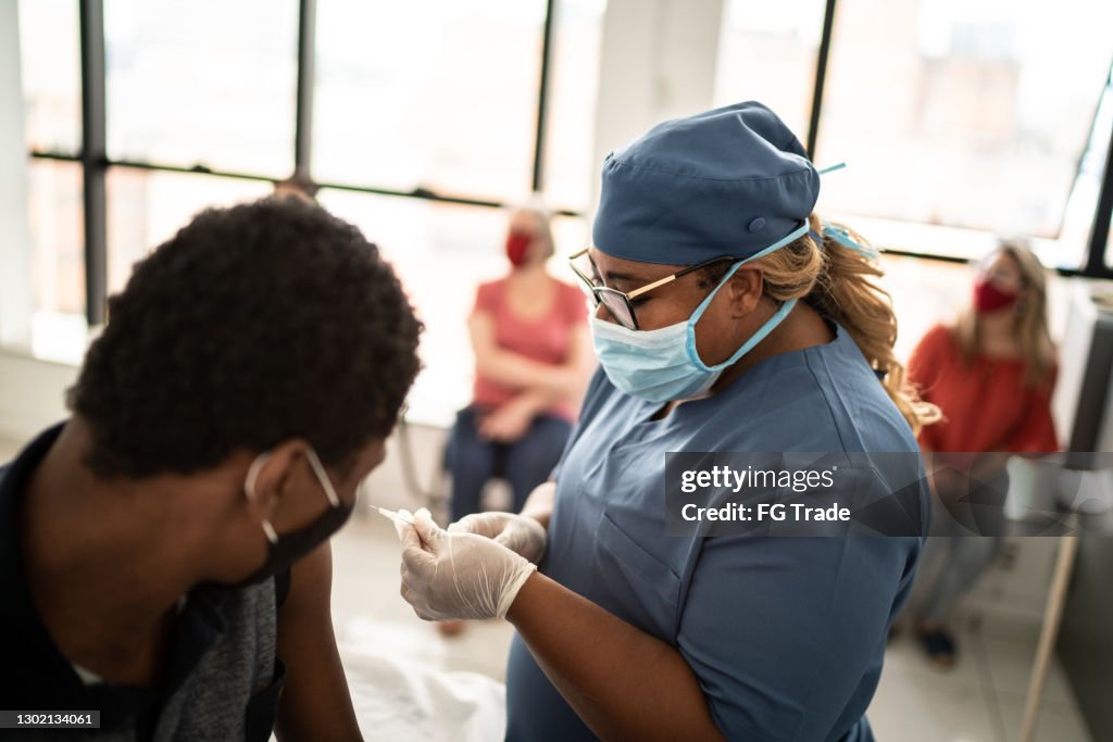 Teenager boy being vaccinated - wearing face mask