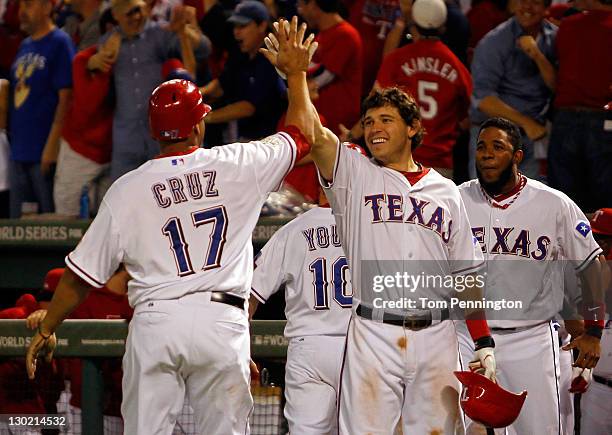 Nelson Cruz, Ian Kinsler and Elvis Andrus of the Texas Rangers celebrate after Cruz scored on a two-run double by Mike Napoli in the eighth inning...