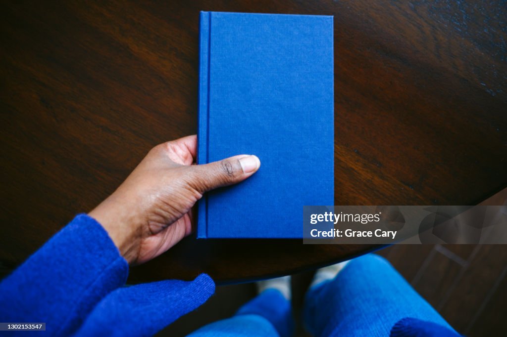 Woman Grabs Book From Table