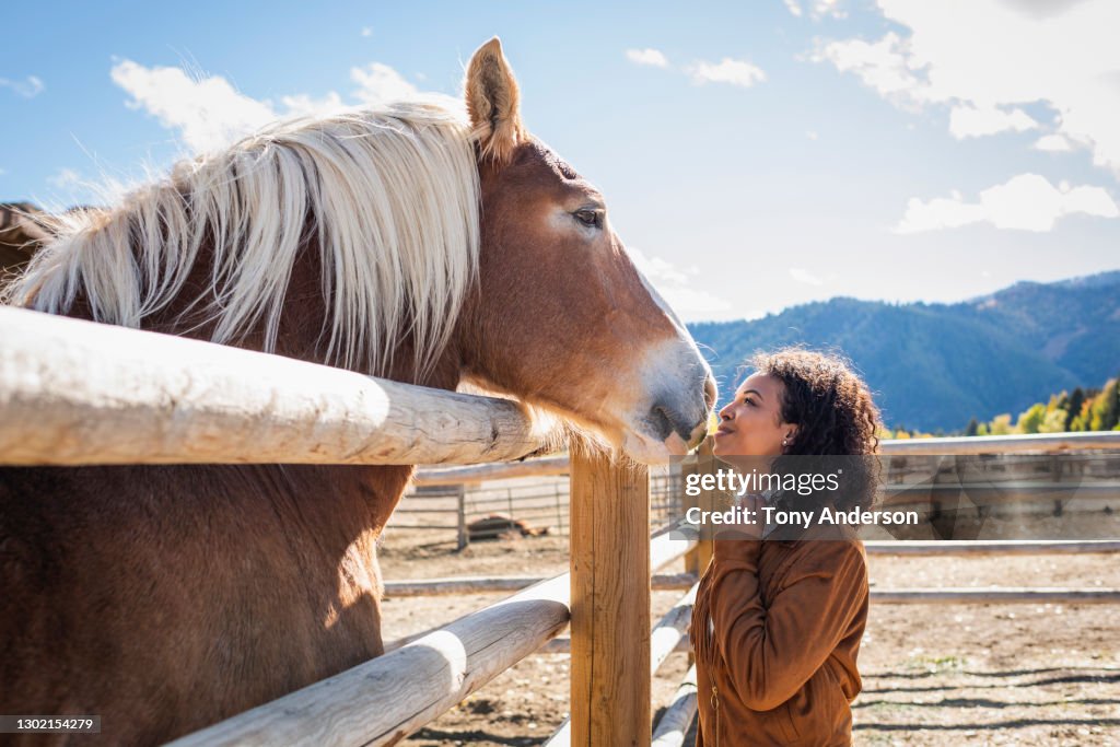 Young woman in western corral with horse